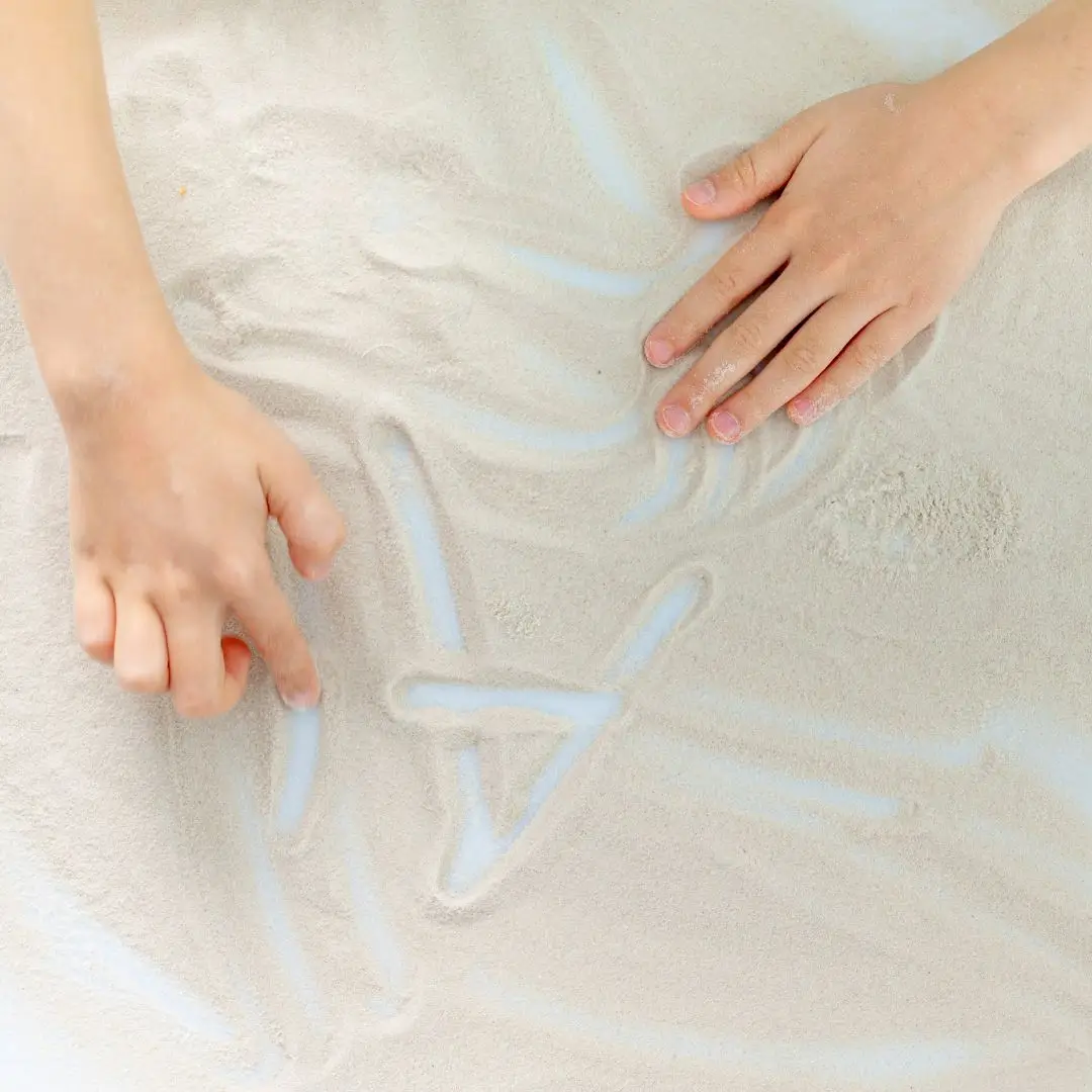 Child writing in sand Montessori Meets Multisensory